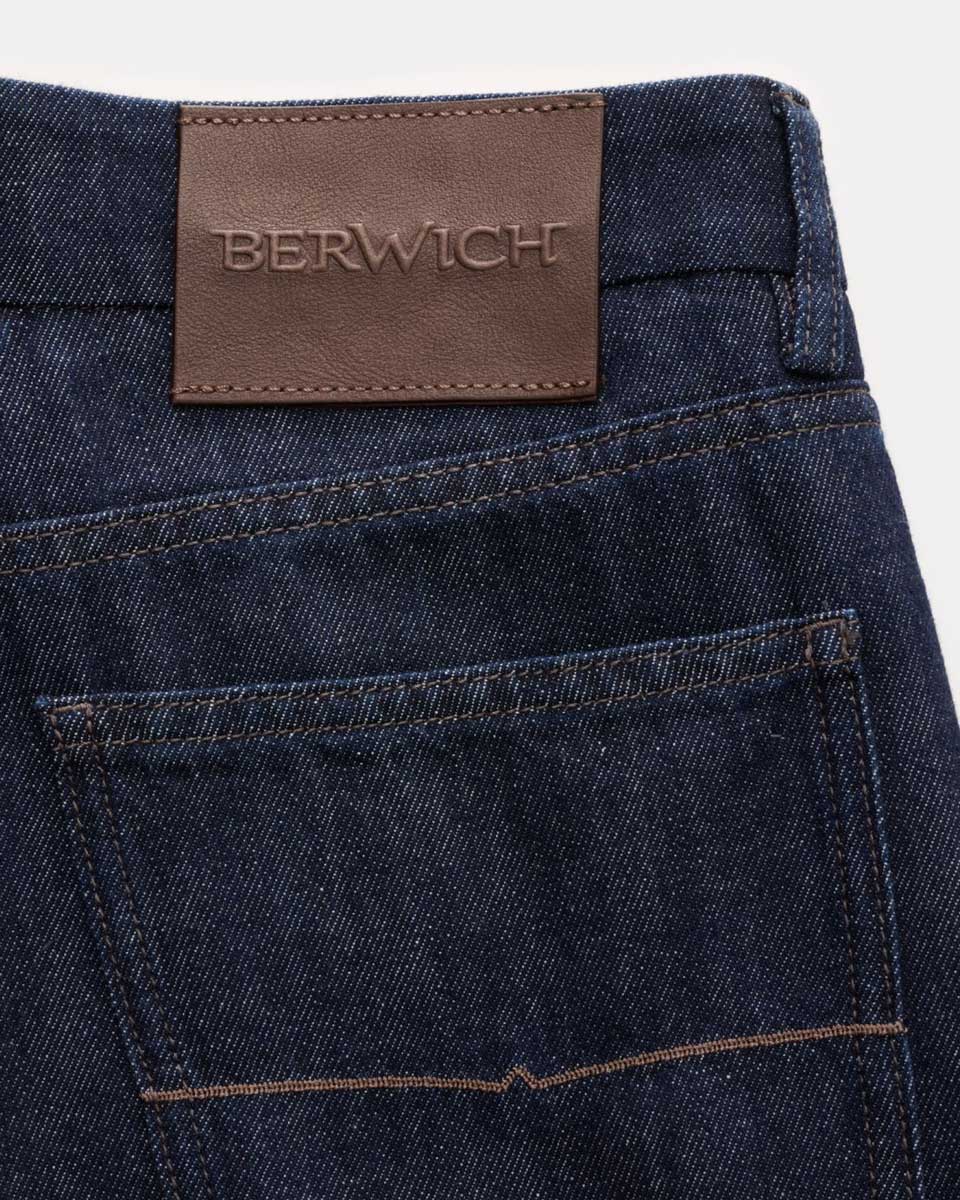 Hintere Ansicht einer dunkelblauen Jeans mit braunem Lederetikett und der Prägung 'BERWICH' über der Gesäßtasche.