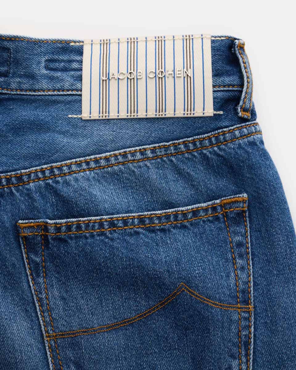 Jeans-Rückseite aus blauem Denim mit orangefarbener Naht und weiß-blau gestreiftem Jacob Cohen Markenlabel.