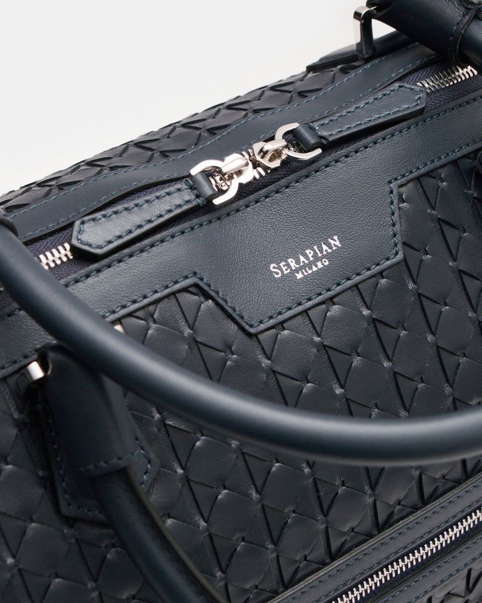 Dunkelblaue Serapian Handtasche aus geflochtenem Leder mit Reißverschluss und silbernen Metallakzenten, Detailansicht.