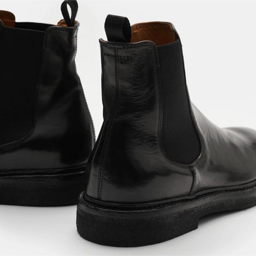 Schwarze Herren Chelsea Boots aus glattem Leder, Rückansicht mit elastischen Seiteneinsätzen und schwarzer Gummisohle.