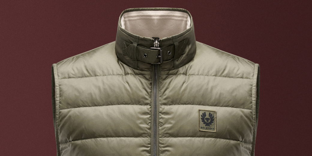 Olivgrüne Daunenweste mit Stehkragen, Reißverschluss und Schnalle am Kragen, Logo-Patch auf der Brust.