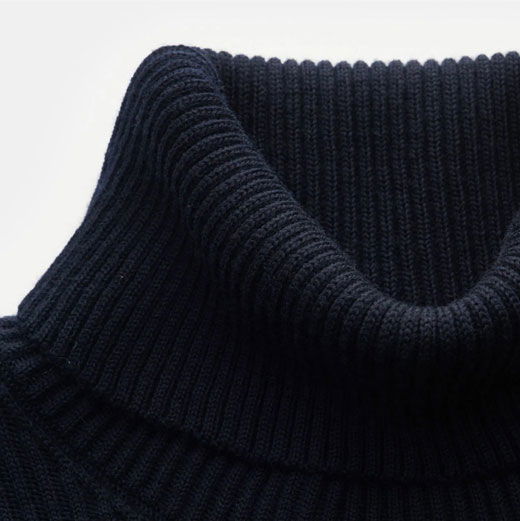 Dunkelblauer, gestrickter Rollkragenpullover aus dickem Rippenstrick, Detailaufnahme des Kragenbereichs.