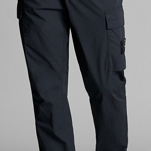Anschnitt einer dunkelblauen Herren-Cargohose mit seitlichen Taschen und markantem Logo-Patch am rechten Bein.
