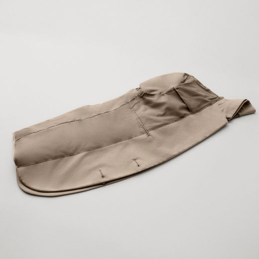 Beige Herren-Sakko, auf links gedreht und gefaltet, liegt flach auf hellem Untergrund, Details der Innenverarbeitung sichtbar.