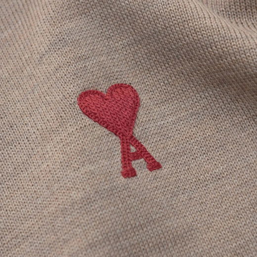 Hellbrauner Herrenpullover mit rotem, gesticktem Designerlogo in Herzform und dem Buchstaben A auf der Brust.