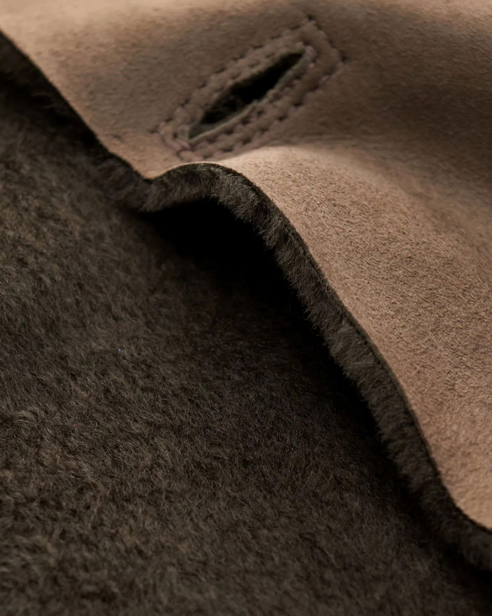 Braune Velourslederjacke mit Knopfleiste, Detailaufnahme des weichen Lammfellfutters und Knopflochnaht.