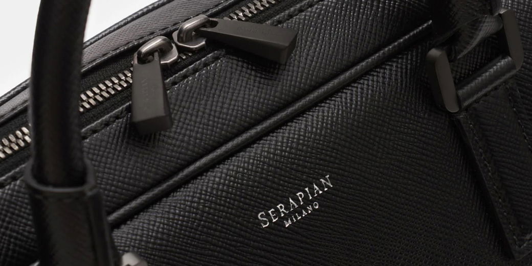 Schwarze Business-Tasche aus strukturiertem Leder mit zwei Reißverschlüssen, Logo-Prägung 'Serapian Milano' und Tragegriff. Schwarze Business-Tasche aus strukturiertem Leder mit zwei Reißverschlüssen, Logo-Prägung 'Serapian Milano' und Tragegriff.