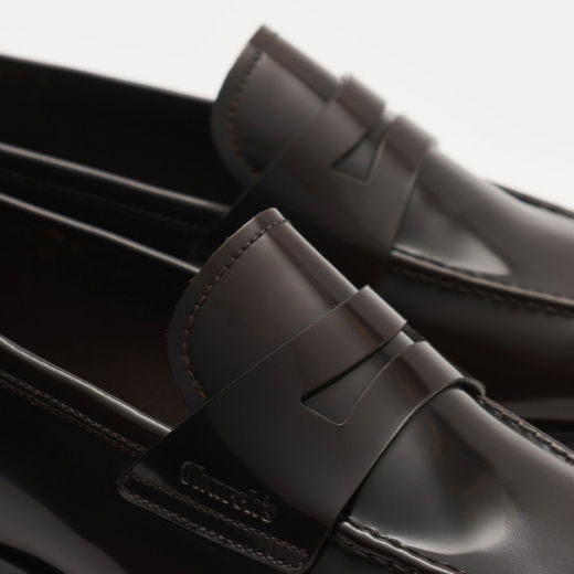 Braune Glattleder-Loafer für Herren mit dekorativem Riemen und feiner Naht, Nahaufnahme von elegantem Schuhpaar. Braune Glattleder-Loafer für Herren mit dekorativem Riemen und feiner Naht, Nahaufnahme von elegantem Schuhpaar.