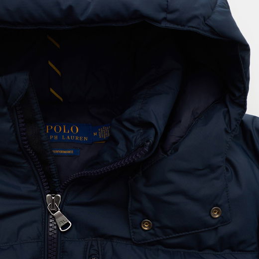 Detailaufnahme der Kapuze und des Reißverschlusses einer dunkelblauen Polo Ralph Lauren Daunenjacke mit Innenlogo.