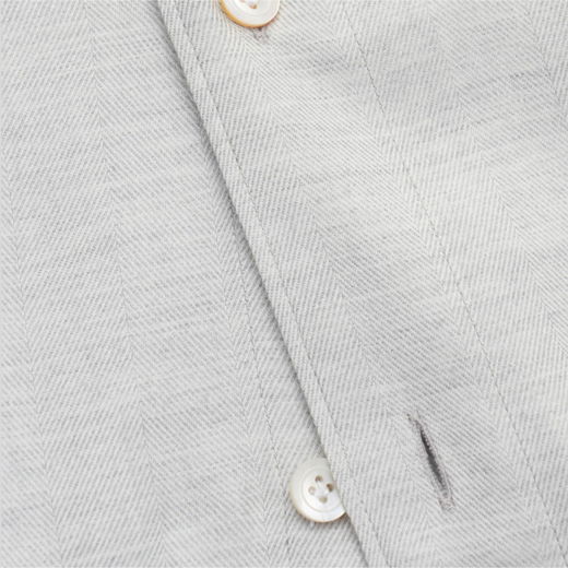 Hellgraues Herrenhemd mit feinem Fischgrätmuster, Knopfleiste und weißen Knöpfen aus Kunststoff, Detailansicht.