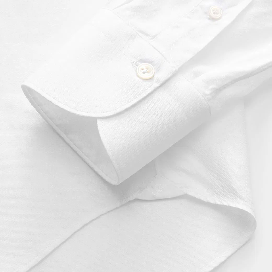 Weiße Herrenhemd-Manschette mit Knopf, feine Baumwollstruktur, sauber verarbeitete Nähte und eleganter Abschluss.