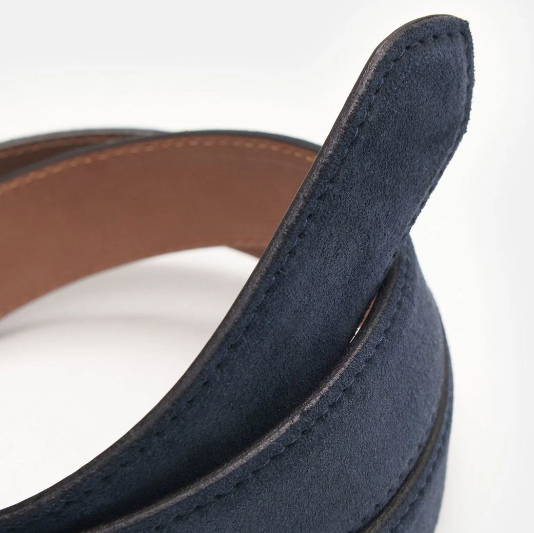 Dunkelblauer Veloursledergürtel für Herren, Detailansicht der spitz zulaufenden Gürtelspitze mit feiner Naht und brauner Innenseite.