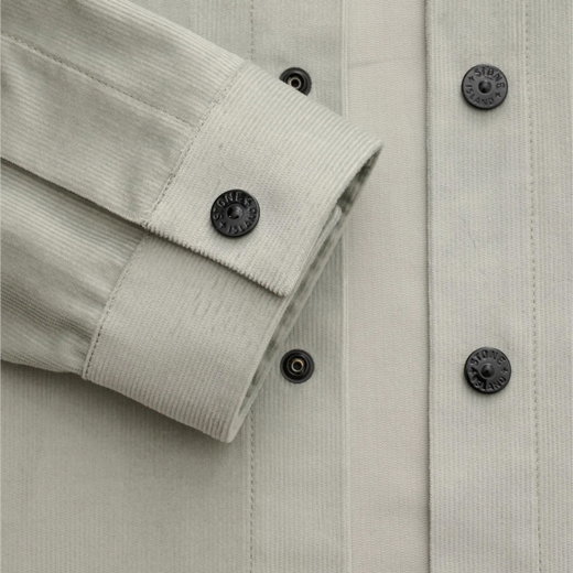 Detailaufnahme eines hellgrauen Hemdjacken-Ärmels mit schwarzer Knopfleiste und schwarzen Druckknöpfen aus Metall.