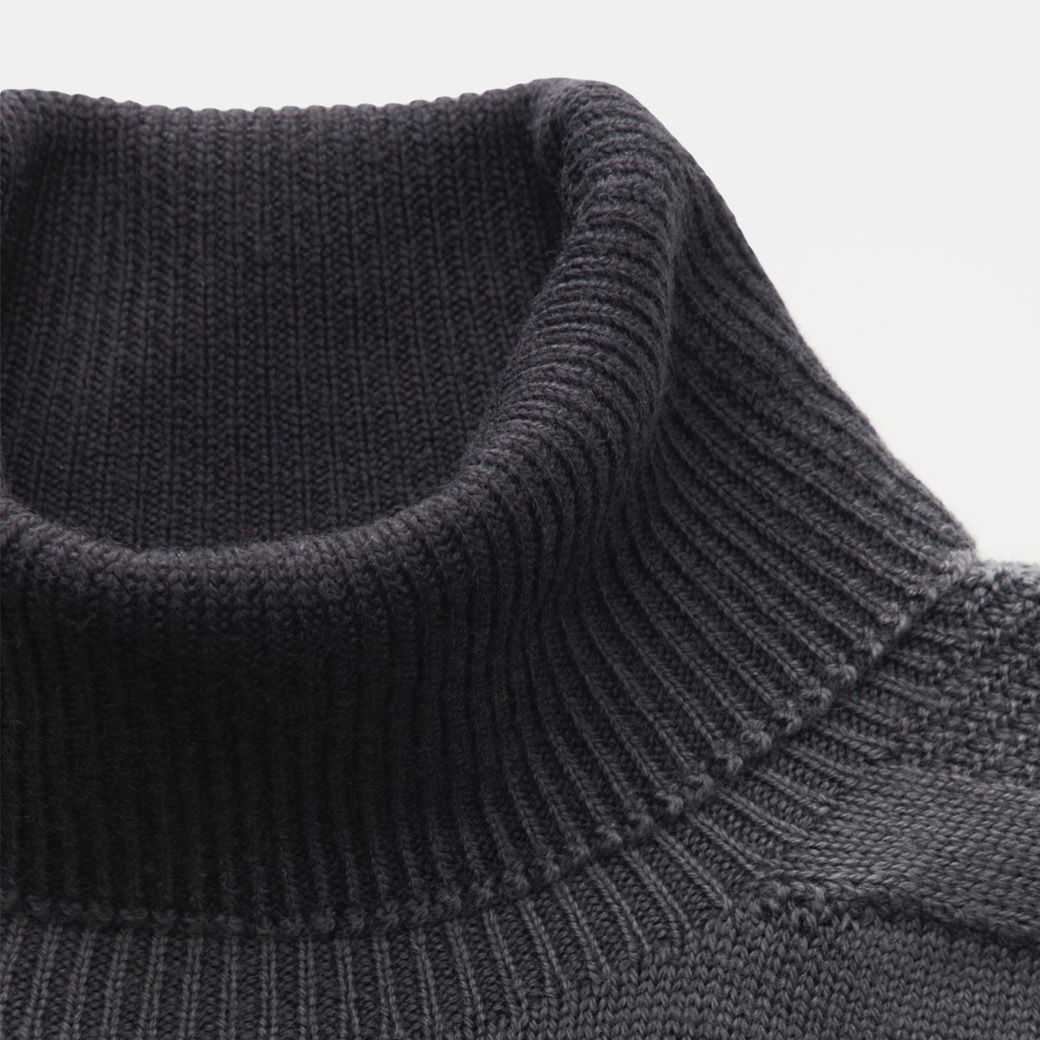 Detailaufnahme des dunkelgrauen, gerippten Rollkragens eines Herrenpullover aus Strickmaterial.