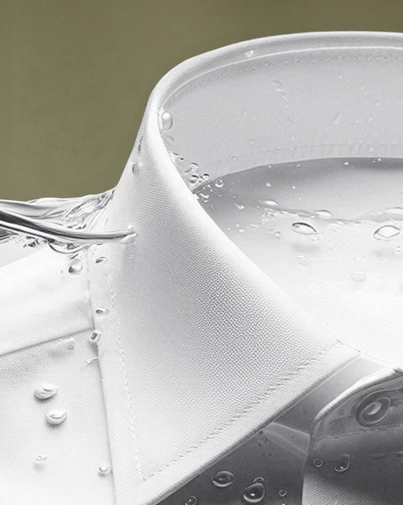 Detailaufnahme eines weißen Herrenhemd-Kragens mit Wasserperlen und fließendem Wasser auf glattem Stoff.