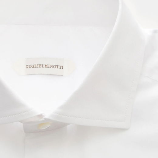 Weißes Herrenhemd mit spitzem Kragen und sichtbarem Designerlabel 'GUGLIELMINOTTI' im Krageninneren. Weißes Herrenhemd mit spitzem Kragen und sichtbarem Designerlabel 'GUGLIELMINOTTI' im Krageninneren.