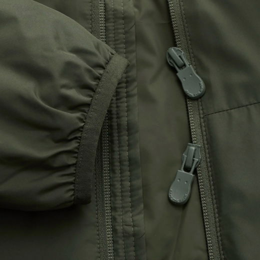 Detailaufnahme eines grünen Herren-Daunenjacken-Ärmels mit elastischem Bündchen und zwei grauen Reißverschluss-Schiebern. Detailaufnahme eines grünen Herren-Daunenjacken-Ärmels mit elastischem Bündchen und zwei grauen Reißverschluss-Schiebern.