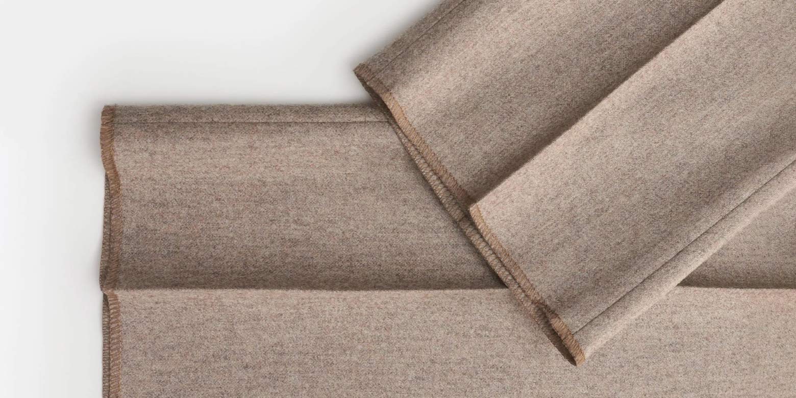 Detailansicht des hellbraunen Saums einer Herrenhose aus Wollstoff mit Bundfalte und sauberer Nahtverarbeitung.