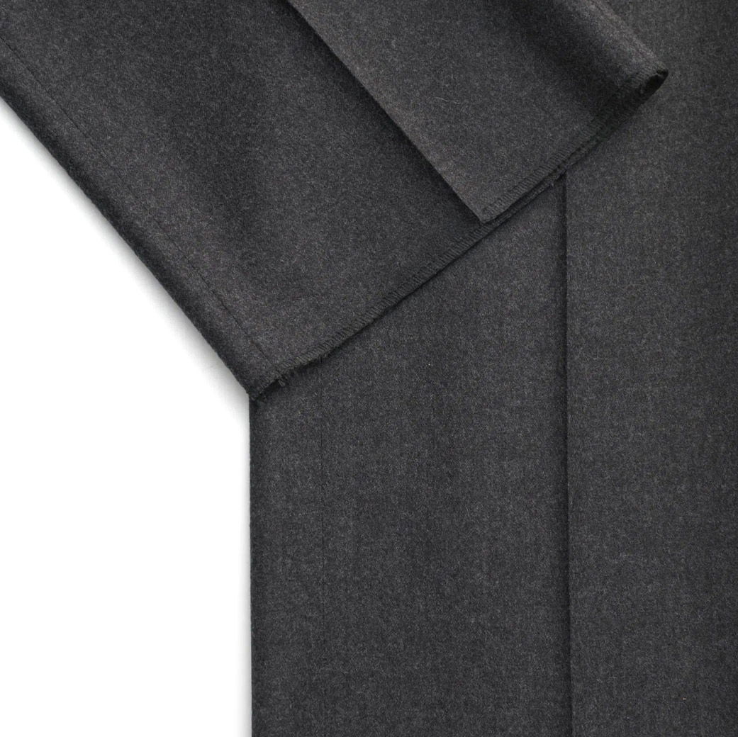 Detailaufnahme des anthrazitfarbenen Saums und der Bundfalte einer Herrenhose aus Wollstoff mit feiner Struktur. Detailaufnahme des anthrazitfarbenen Saums und der Bundfalte einer Herrenhose aus Wollstoff mit feiner Struktur.