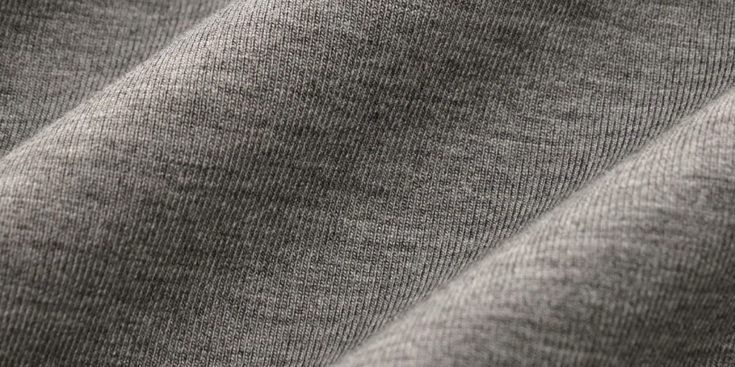 Detailaufnahme eines grauen Jerseystoffes aus Viskose mit feiner, gleichmäßiger Maschenstruktur und weicher Textur.