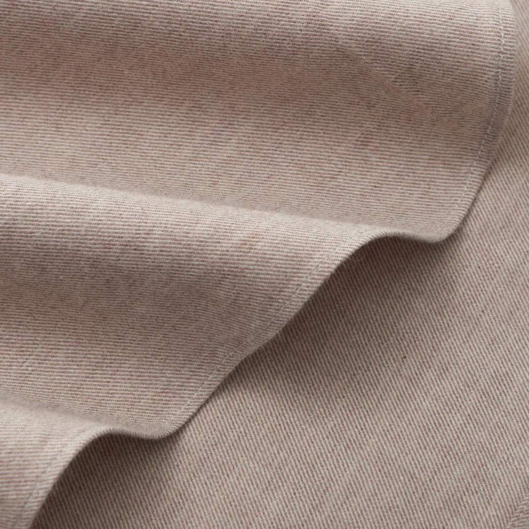 Beigefarbener, fein gerippter Flanellstoff mit weicher, leicht strukturierter Oberfläche und sichtbaren Falten.