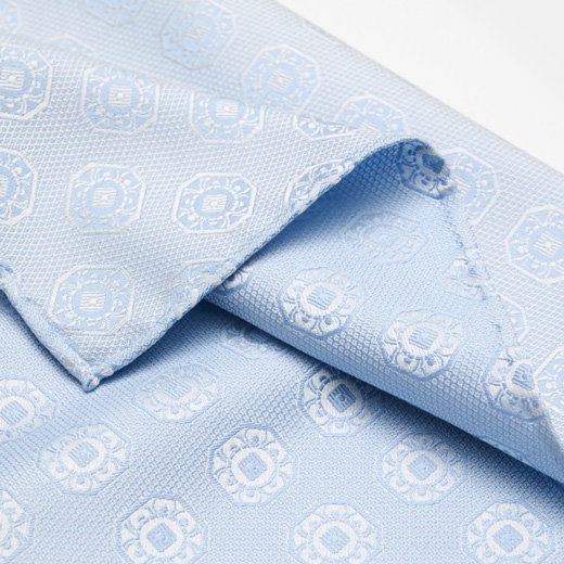 Hellblaues Einstecktuch mit feinem, geometrischem Muster aus floralen, runden Ornamenten in Nahaufnahme.