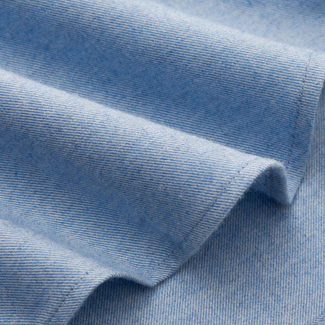 Hellblauer Flanellstoff mit feiner Struktur und sichtbarer Naht, der weich und leicht gerafft liegt.