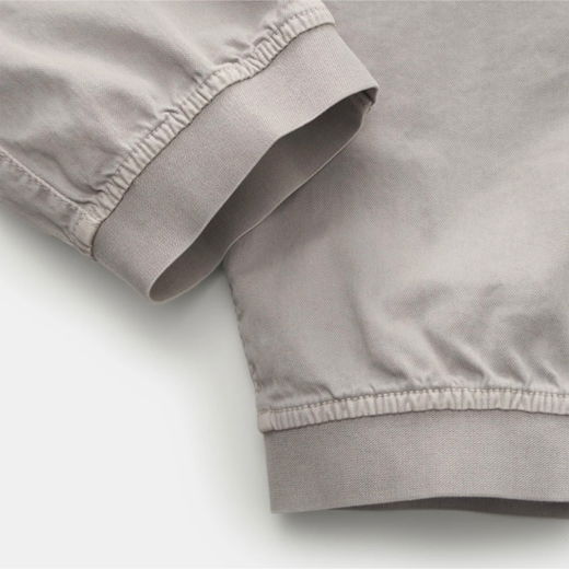 Detailaufnahme eines hellgrauen Herren-Jogginghosen-Beinabschlusses mit elastischem Bündchen aus weichem Stoff.