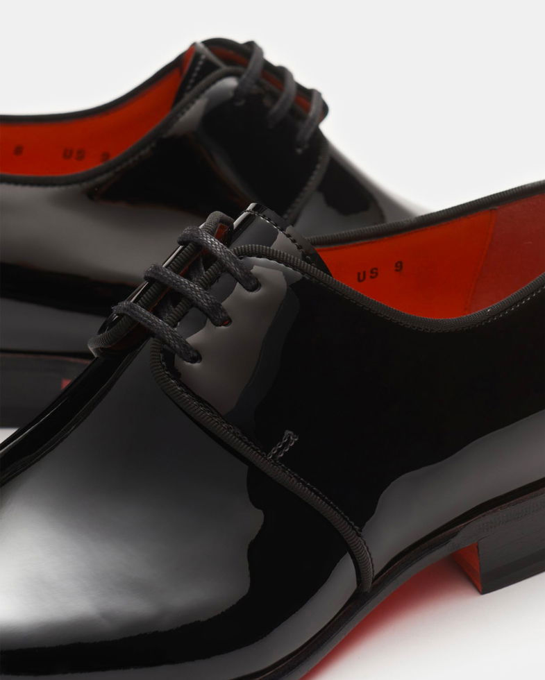 Schwarze, glänzende Glattleder-Herrenschnürschuhe mit schwarzer Schnürung und rotem Innenfutter, Nahaufnahme. Schwarze, glänzende Glattleder-Herrenschnürschuhe mit schwarzer Schnürung und rotem Innenfutter, Nahaufnahme.
