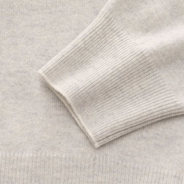Beige Kaschmirpullover für Herren, Detailaufnahme des gerippten Ärmels und Saums mit feiner Strickstruktur.