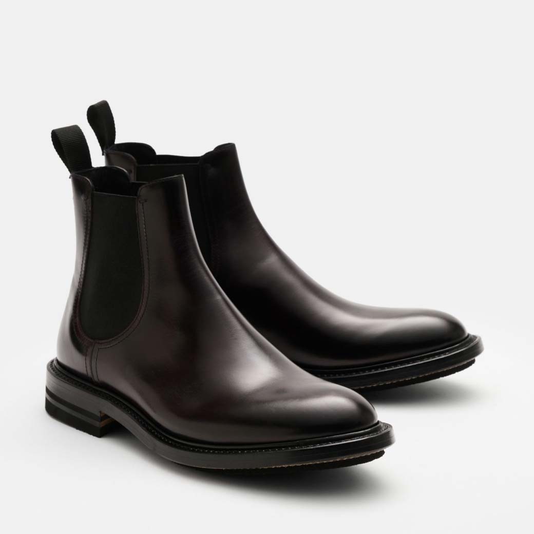 Ein Paar dunkelbraune Herren-Chelsea-Boots aus glattem Leder mit elastischen Seiteneinsätzen und Zuglaschen.