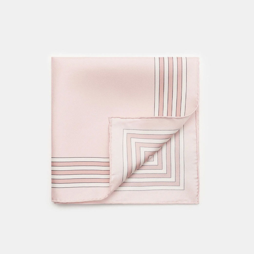 Gefaltetes Seideneinstecktuch in zartem Rosa mit weißen und schwarzen Streifen, Ecke umgeschlagen, auf weißem Hintergrund. Gefaltetes Seideneinstecktuch in zartem Rosa mit weißen und schwarzen Streifen, Ecke umgeschlagen, auf weißem Hintergrund.