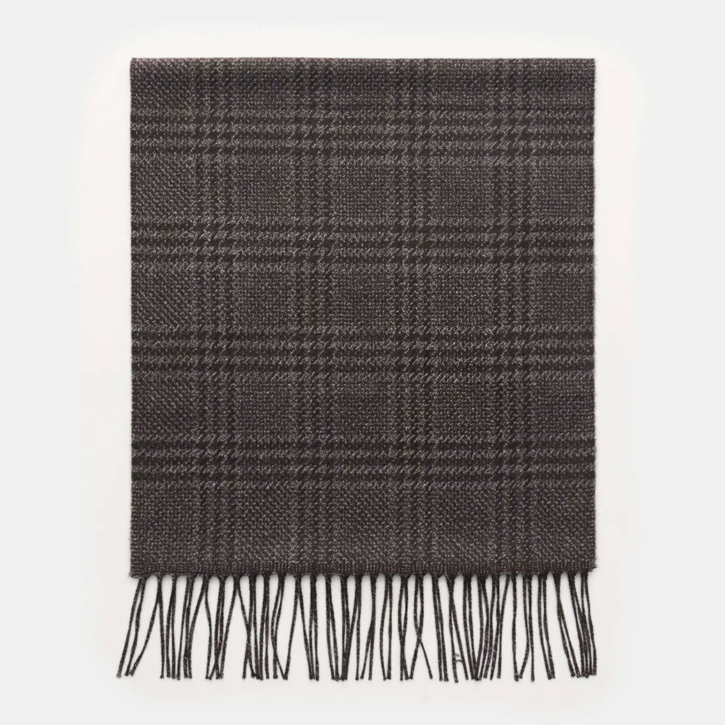 Dunkelgrauer Herren-Schal mit schwarzem Karomuster und langen Fransen, flach liegend auf weißem Hintergrund. Dunkelgrauer Herren-Schal mit schwarzem Karomuster und langen Fransen, flach liegend auf weißem Hintergrund.