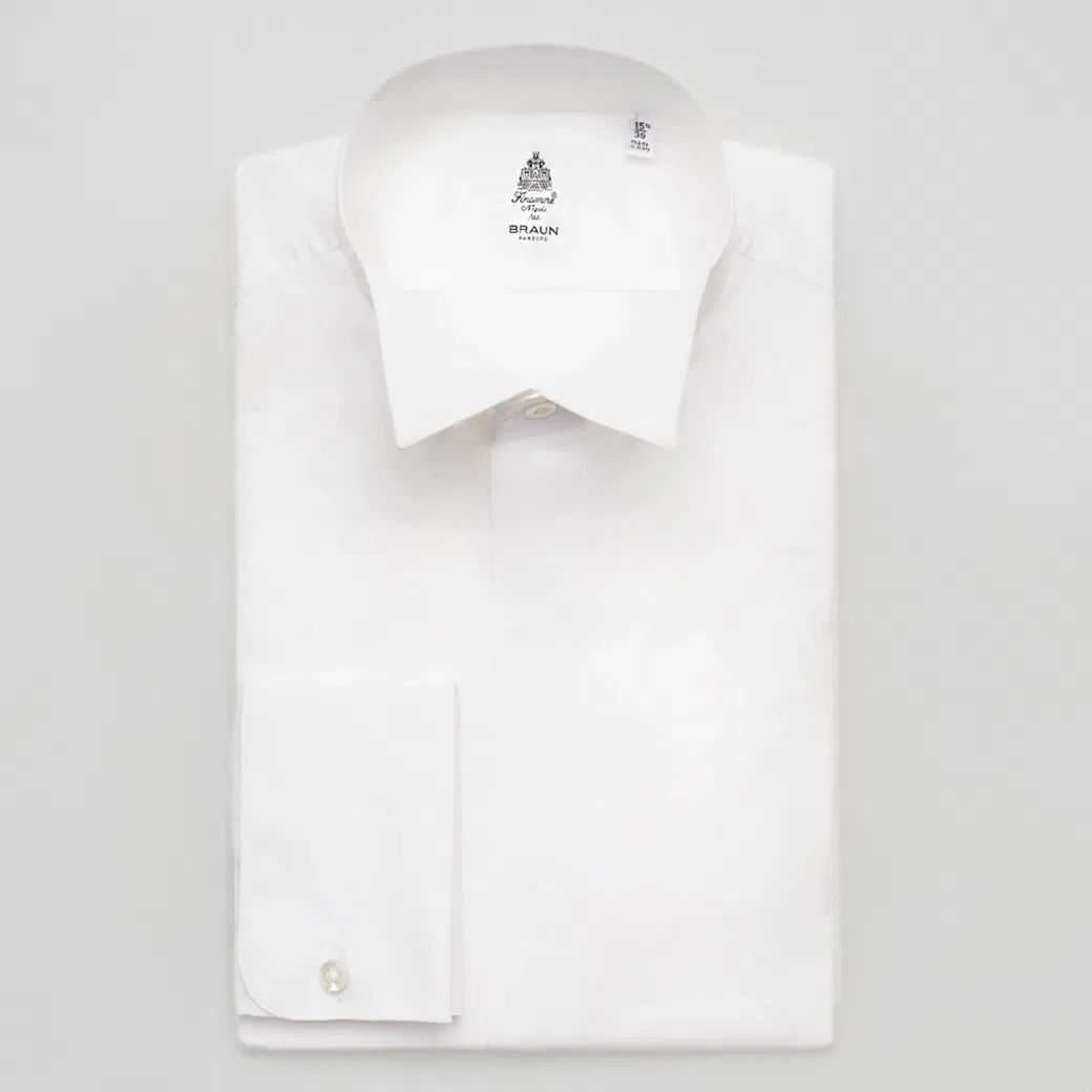 Gefaltetes weißes Herrenhemd mit klassischem Kragen und Manschette, Innenseite mit Designeraufdruck von Braun Hamburg. Gefaltetes weißes Herrenhemd mit klassischem Kragen und Manschette, Innenseite mit Designeraufdruck von Braun Hamburg.