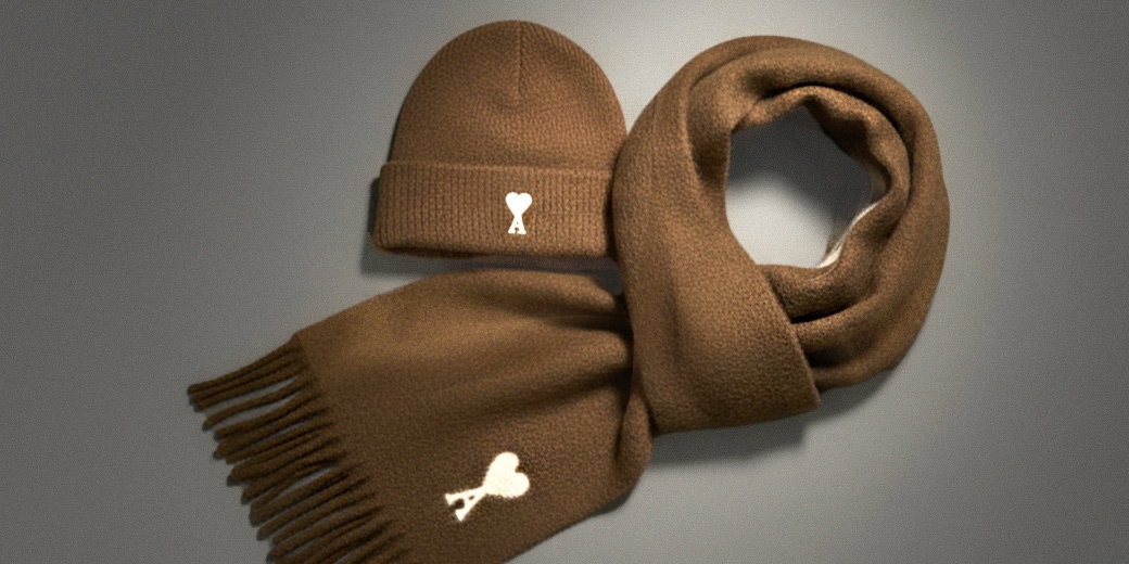 Braunes Strick-Set mit Mütze und Schal, beide mit weißem Ami Paris Designerlogo, Schal mit Fransen, flach liegend. Braunes Strick-Set mit Mütze und Schal, beide mit weißem Ami Paris Designerlogo, Schal mit Fransen, flach liegend.