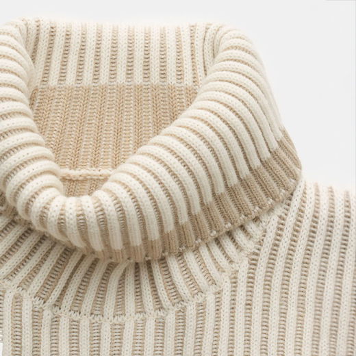 Gerippter Rollkragenpullover für Herren in Beige mit hellbraunem Rand, Nahaufnahme des Kragens und Strickmusters. Gerippter Rollkragenpullover für Herren in Beige mit hellbraunem Rand, Nahaufnahme des Kragens und Strickmusters.