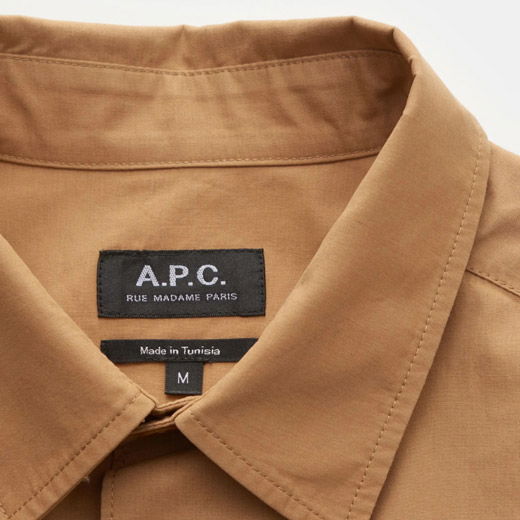 Braunes Herrenhemd mit offenem Kragen, sichtbarem A.P.C. Designerlabel und Herstellungsangabe 'Made in Tunisia', Größe M.