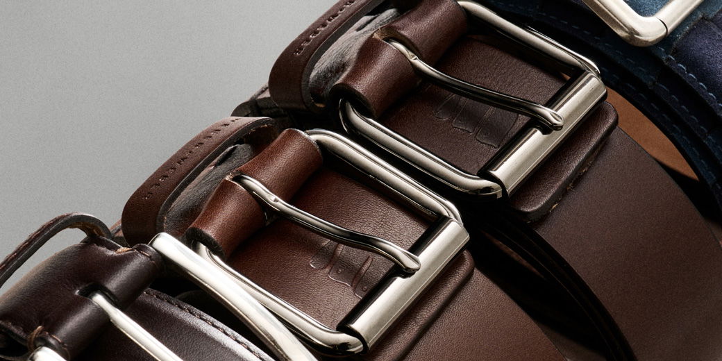 Nahaufnahme mehrerer nebeneinander liegender Ledergürtel in verschiedenen Brauntönen mit silbernen Metallschnallen.