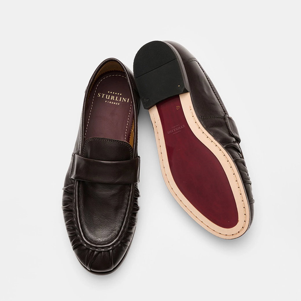 Dunkelbraune Herren-Lederloafer mit roter Ledersohle, schwarzer Fersenkappe und Prägung innen 'Sturlini Firenze'.