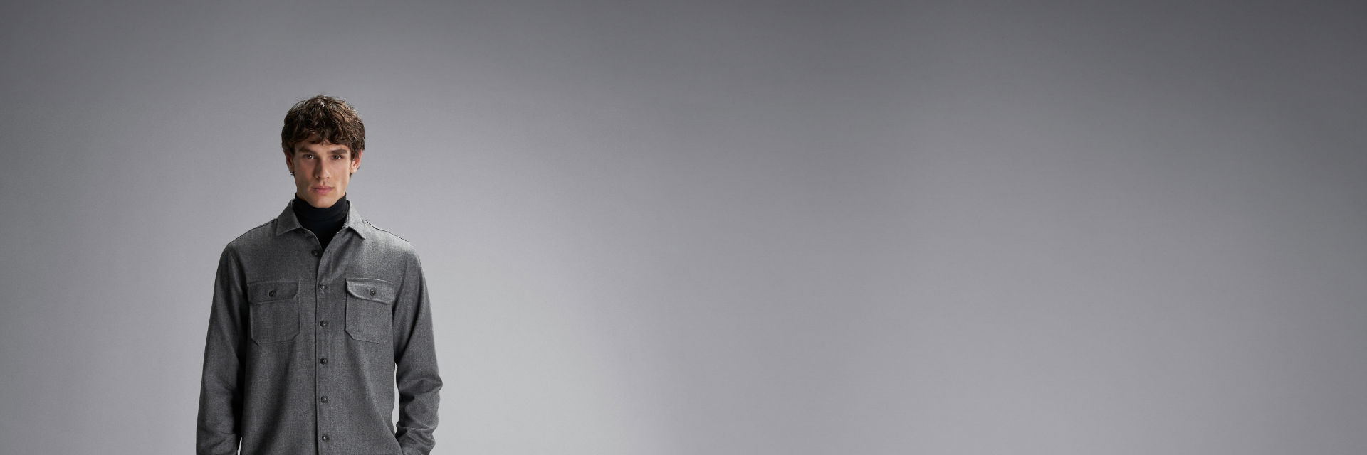 Herr mit dunkelgrauem Overshirt, schwarzem Rollkragenpullover und dunkler Hose Herr mit dunkelgrauem Overshirt, schwarzem Rollkragenpullover und dunkler Hose