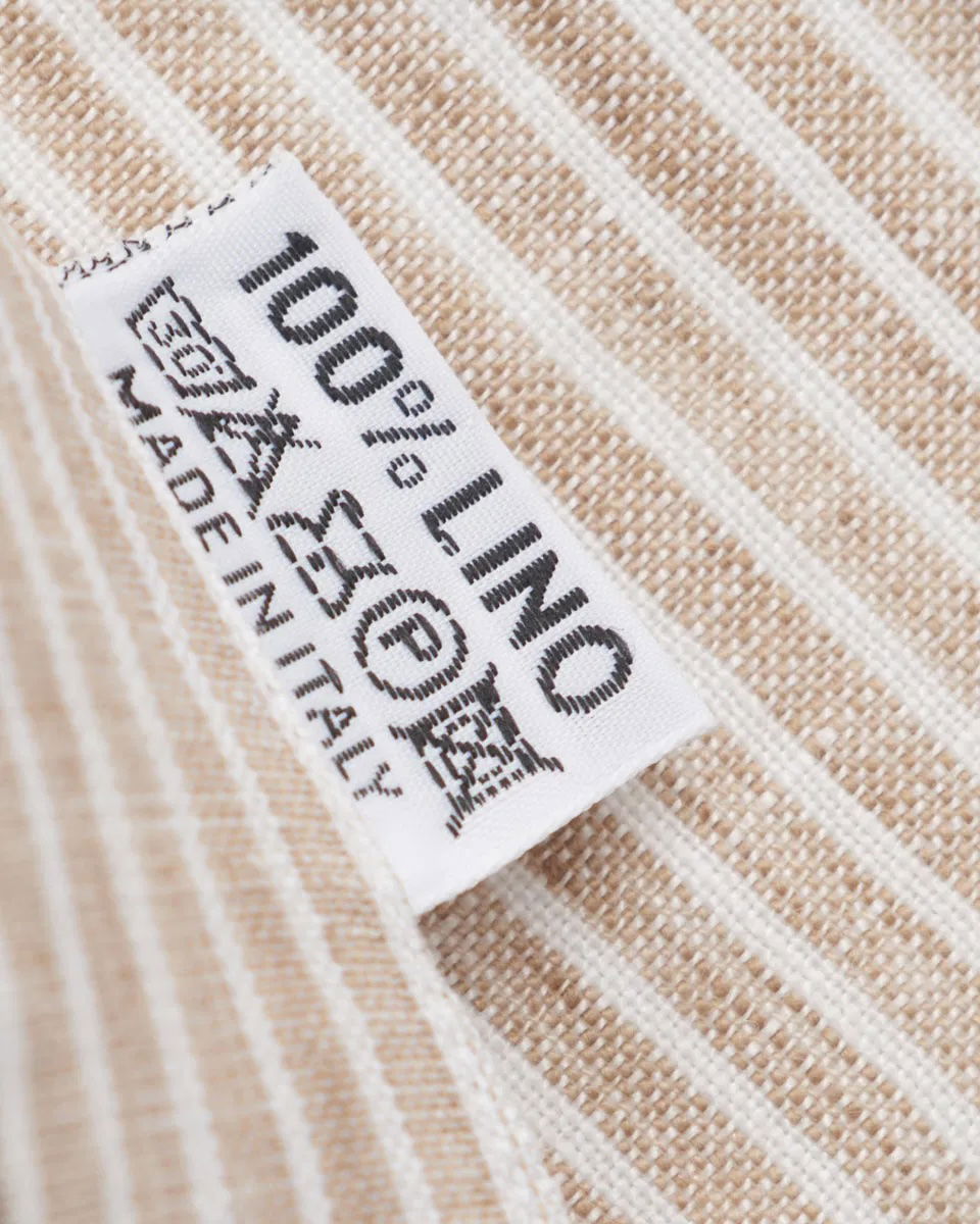 Pflegeetikett eines weiß-beige gestreiften Leinenshirts mit Text 100% LINO und Made in Italy.