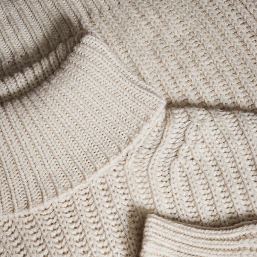 Detailansicht des Rollkragens eines beigefarbenen Strickpullovers mit Strukturmuster für Herren aus Kaschmir Detailansicht des Rollkragens eines beigefarbenen Strickpullovers mit Strukturmuster für Herren aus Kaschmir