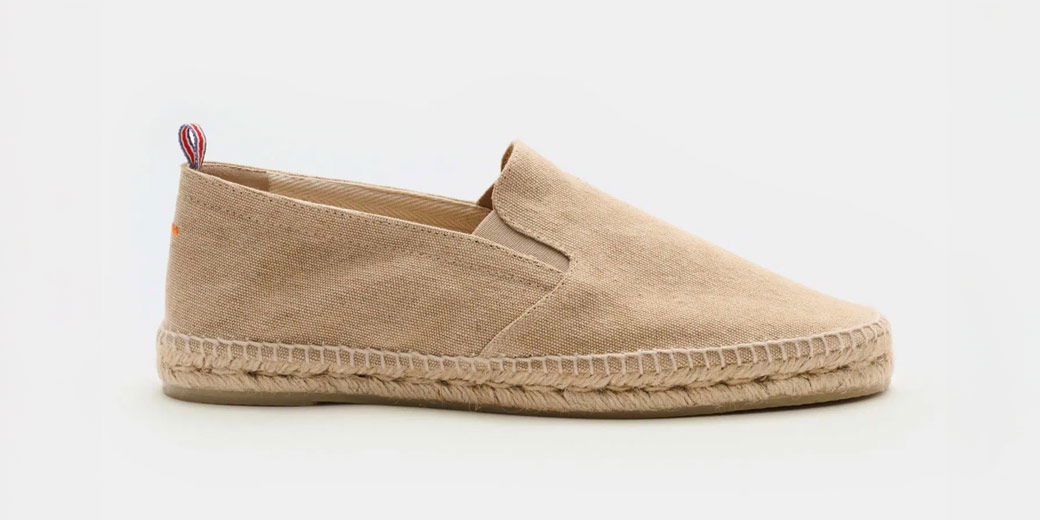 Hellbraune Herren-Espadrilles aus Stoff mit geflochtener Jutsohle, seitliche Ansicht, rot-blau-weißer Fersenlasche.