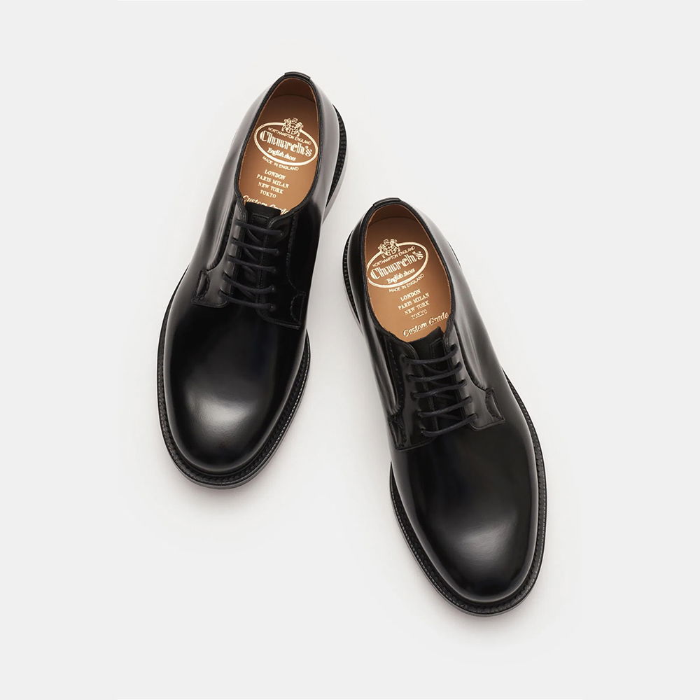 Schwarze Herren-Schnürschuhe aus Glattleder, von oben fotografiert, mit braunem Innenfutter und gedrucktem Markenlogo. Schwarze Herren-Schnürschuhe aus Glattleder, von oben fotografiert, mit braunem Innenfutter und gedrucktem Markenlogo.