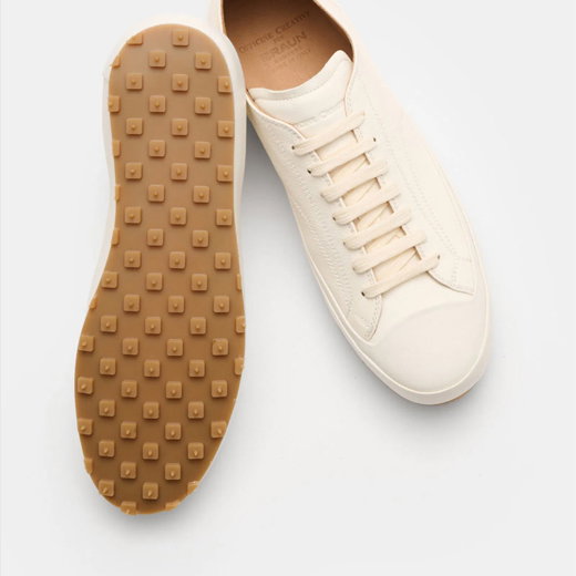 Weißer Herren-Ledersneaker mit runder Spitze, beiger Gummisohle mit quadratischen Profilnoppen, Vorder- und Rückansicht.