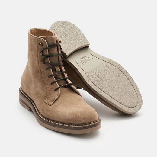 Beigefarbene Herren-Schnürboots aus Veloursleder, Vorderansicht und Unterseite mit brauner Gummisohle und schwarzen Schnürsenkeln. Beigefarbene Herren-Schnürboots aus Veloursleder, Vorderansicht und Unterseite mit brauner Gummisohle und schwarzen Schnürsenkeln.