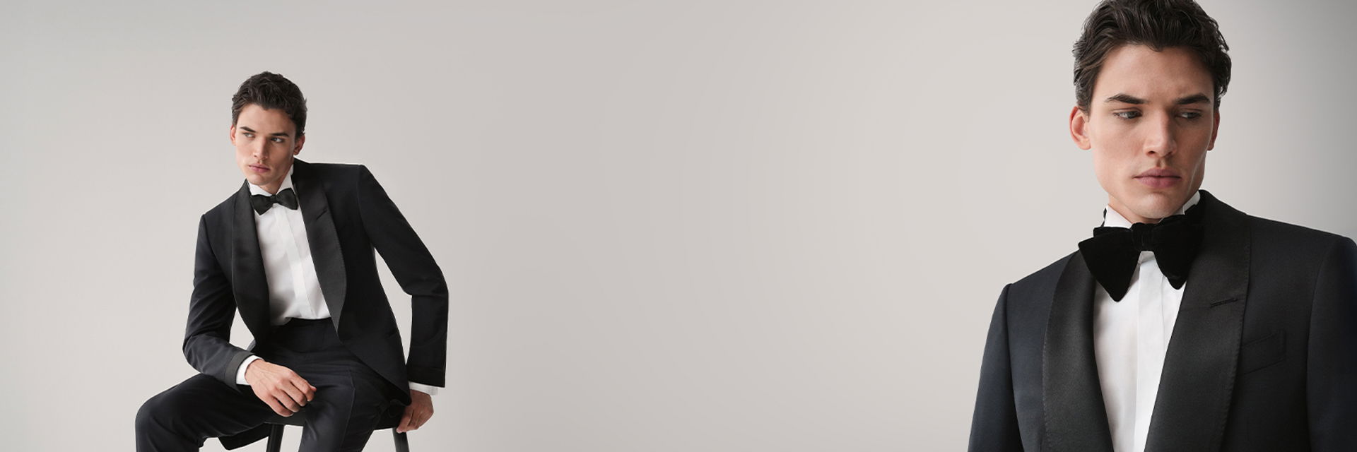 Eleganter junger Mann in schwarzem Smoking mit schwarzer Fliege und weißem Hemd, sitzend und stehend vor hellgrauem Hintergrund. Eleganter junger Mann in schwarzem Smoking mit schwarzer Fliege und weißem Hemd, sitzend und stehend vor hellgrauem Hintergrund.