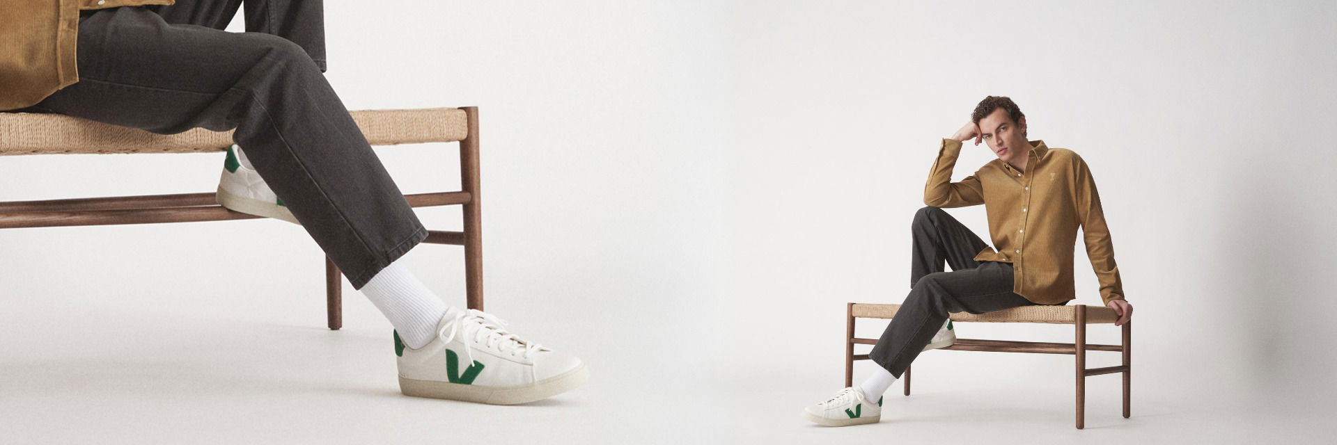 Mann in braunem Overshirt und schwarzer Jeans sitzt auf Bank, Nahaufnahme weißer Sneaker mit grünem Logo und weißen Socken. Mann in braunem Overshirt und schwarzer Jeans sitzt auf Bank, Nahaufnahme weißer Sneaker mit grünem Logo und weißen Socken.