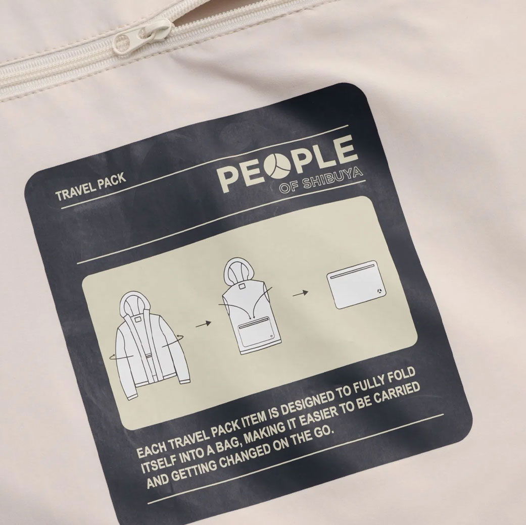 Anleitungsgrafik auf Tasche zeigt, wie eine Jacke zu einem kleinen Beutel zusammengefaltet wird, Text 'PEOPLE OF SHIBUYA'.