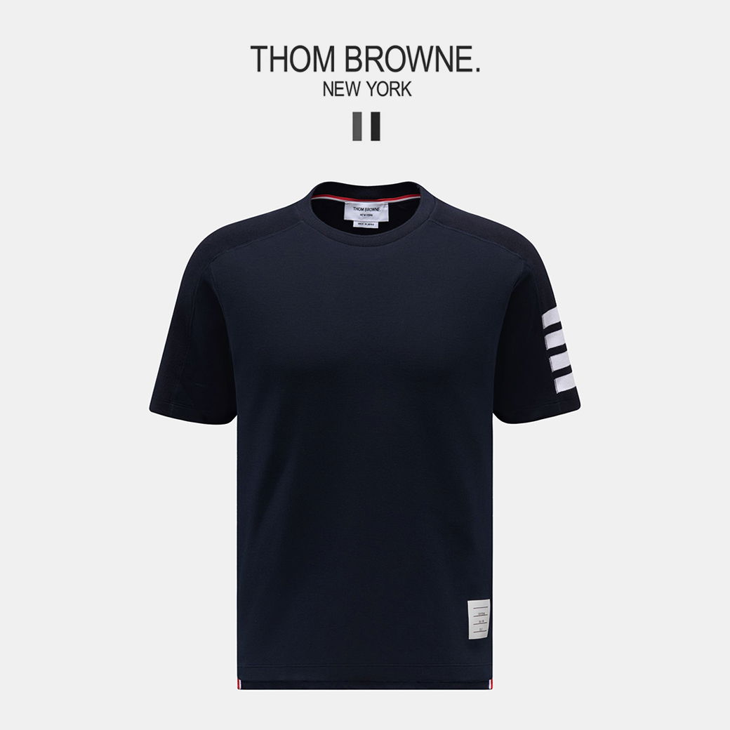 Dunkelblaues Thom Browne T-Shirt mit rundem Kragen, weißen Streifen am linken Ärmel und kleinem Label vorne unten. Dunkelblaues Thom Browne T-Shirt mit rundem Kragen, weißen Streifen am linken Ärmel und kleinem Label vorne unten.